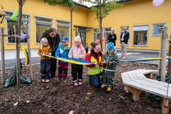 Rektor Mari Wennberg tillsammans med personal och förskolebarn klipper av invigningsbandet. framför Lövstalöts nya förskola (foto: Addlight)