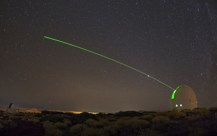En synlig grön laser lyste från ESA: s Optical Ground Station (OGS). En del av Teide-observatoriet, OGS, som ligger 2400 meter över havet på den vulkaniska ön Teneriffa, används för utveckling av optiska kommunikationssystem för rymden såväl som rymdavfall och objekt nära jorden. Foto: IAC– Daniel López