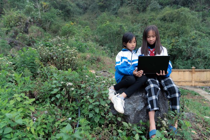 Två flickor i Lai Châu-provinsen i Vietnam deltar i Plan Internationals kurser för att öka den digitala kompetensen och tryggheten online.