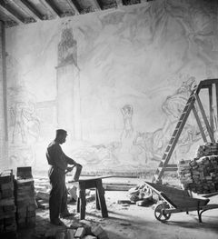 Murare i arbete i Blå rummet. I bakgrunden syns Axel Törnemans al secco-målning ”Apoteos över Stockholm som sjöstad”.
Fotografi från 1922. Fotograf okänd.
