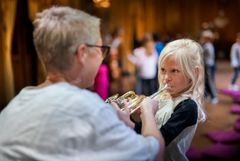 Skolbarn får chans att prova blåsinstrument tillsammans med musiker i Kungliga Hovkapellet. Foto: Kungliga Operan