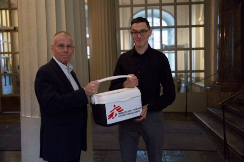 Läkare Utan Gränsers humanitära rådgivare Pieter-Jan van Eggermont (till höger) lämnar över underskrifterna från namninsamlingen till Anders Nordström, ambassadör för global hälsa på Utrikesdepartementet. Foto: Tove Tikkanen Jönn.