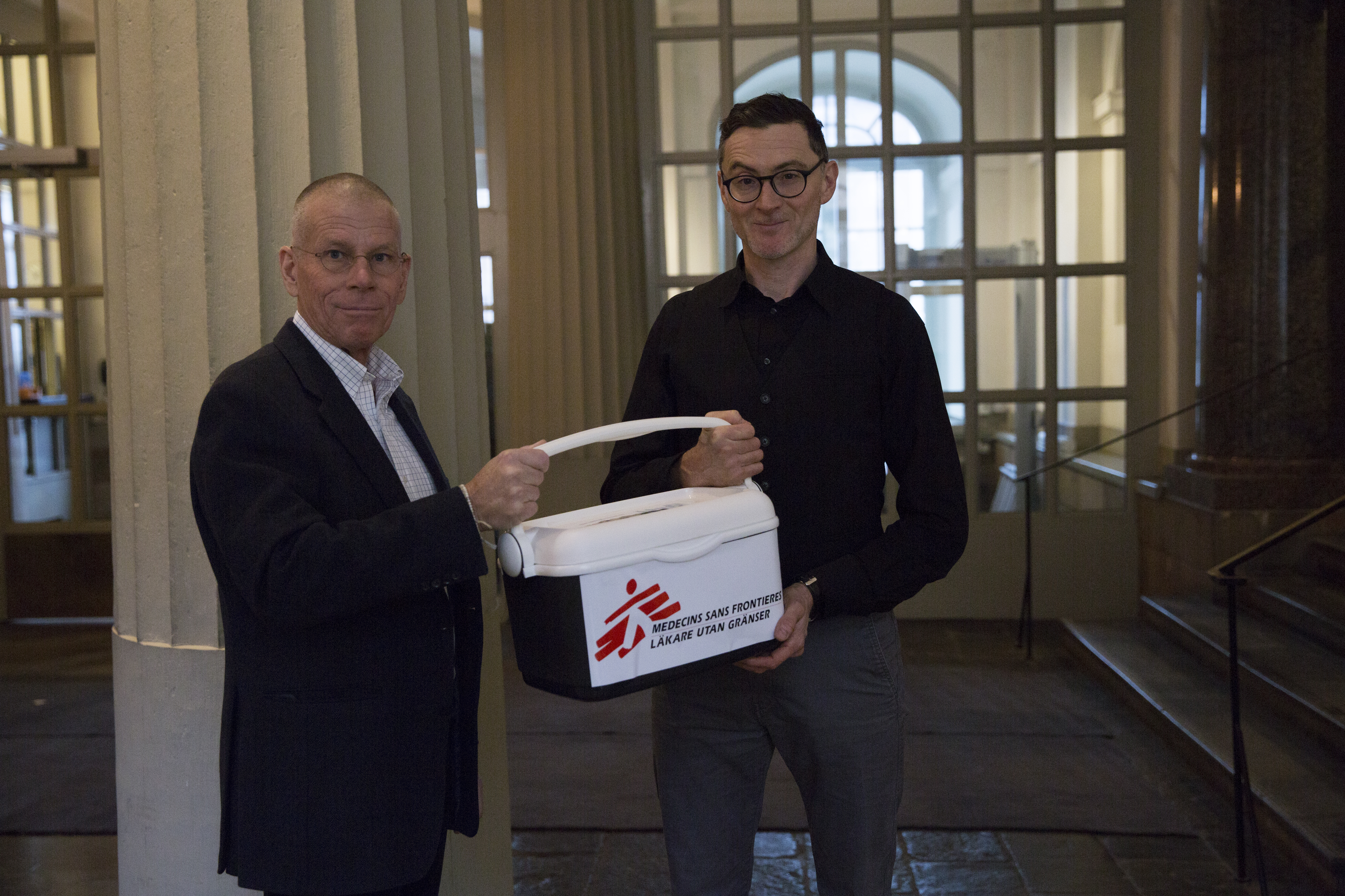 Läkare Utan Gränsers humanitära rådgivare Pieter-Jan van Eggermont (till höger) lämnar över underskrifterna från namninsamlingen till Anders Nordström, ambassadör för global hälsa på Utrikesdepartementet. Foto: Tove Tikkanen Jönn.