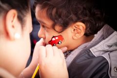 Pojke blir ansiktsmålad, Rinkebystråket. Foto: Markus Hallberg