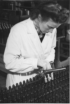 Gittan Schwartzberg fyller flaskor på Gahns tvålfabrik i Uppsala. Bild från Uppsala industriminnesförenings samlingar.