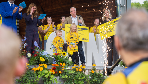 Micael Mathsson t.f generalsekreterare på Barncancerfonden tar emot en check på närmare 30 miljoner av Team Rynkeby. Fotograf: Albin Karlén