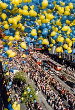 Vy över Klarabergsgatan i Stockholm utsmyckad med ballonger i blått och gult och kantad med tusentals människor som är på plats för att få en skymt av och hylla bronshjältarna i det svenska landslaget vid deras hemkomst 18 juli 1994, efter fotbolls-VM i USA. Foto: Anders Wiklund/TT