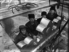 Grupp av arbetare vid monteringen av de tre kronorna på tornet. Okänd fotograf, 1920.