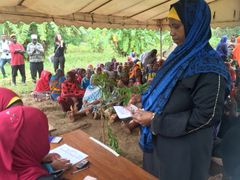 Kvinnor får kontantstöd inom ramen för PSSN-programmet som Sida stödjer i Tanzania. Foto: Gisela Strand/Sida
Syntolkning: En kvinna står vid ett bord och håller ett papper och några sedlar i handen.