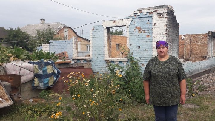 Tetyana Topal utanför sitt förstörda hus i Moschun. Foto: Olena Oliynyk