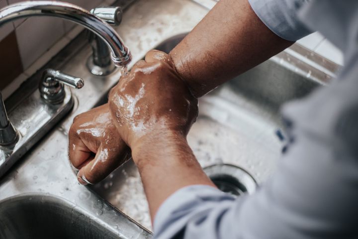 Händer som tvättas under vattenkran.