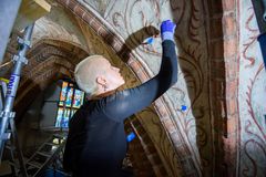 Bildtext: Att renovera ett kyrkorum kräver specialistkunskaper och varsamhet. Albertus Pictors takmålningar från 1400-talet rengörs med en deg av vetemjöl, vatten och kemikalier som konservatorerna använder för att ta bort smuts och beläggningar. Foto: Magnus Aronson/ Ikon