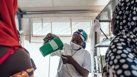 Safaratu Tambaya, som arbetar på Läkare Utan Gränsers undernäringsklinik på Maiyama-sjukhuset i Kebbi, Nigeria, häller upp näringsberikad mjölk som används för att behandla undernäring. Foto: KC NWAKALOR