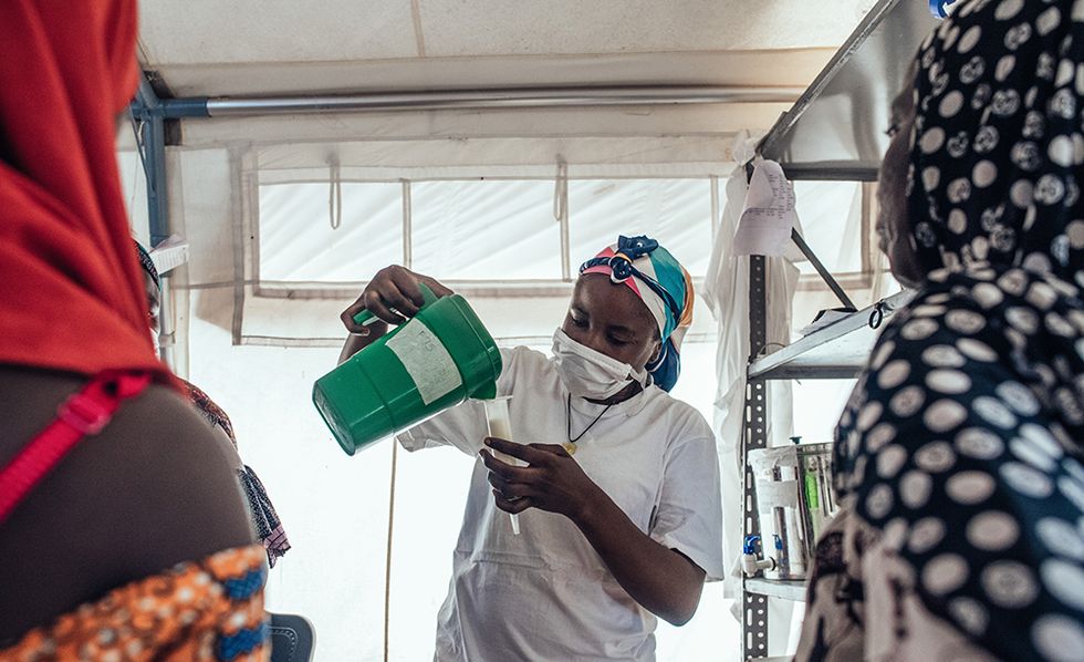 Safaratu Tambaya, som arbetar på Läkare Utan Gränsers undernäringsklinik på Maiyama-sjukhuset i Kebbi, Nigeria, häller upp näringsberikad mjölk som används för att behandla undernäring. Foto: KC NWAKALOR
