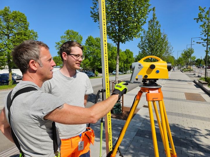 Mattias Arvidsson och Peter Isaksson från kommunens geodataenhet jobbar med stomnätets utbyggnad. Här placerar de ut nya mätpunkter längs Mälarvägen i höjd med platsen där de klassiska kvarteren planeras. Foto: Daniel Jansson, Upplands Väsby kommun