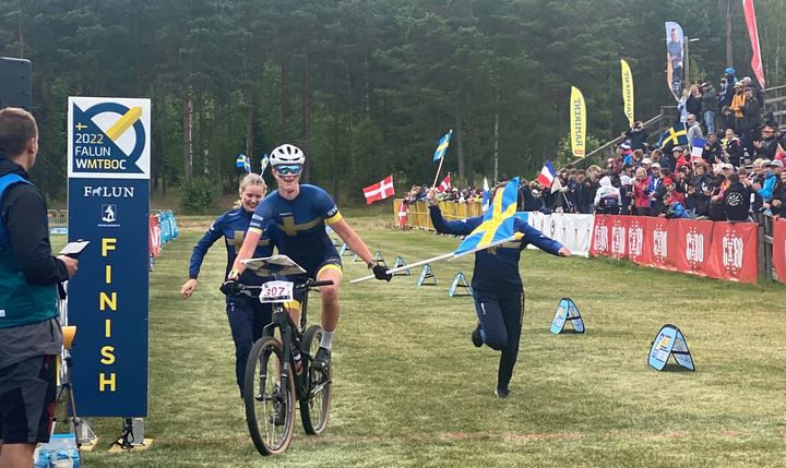 Tilda Palm cyklar över mållinjen när Sveriges juniordamer tar guld i stafett. Fotograf: Malin Dunfors.