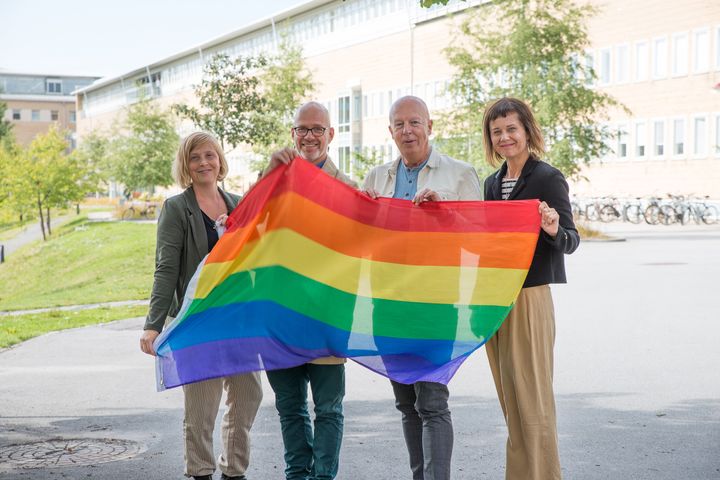 Kyrkan på Campus rullar ut prideflaggan inför helgens Umepride. Åsa Bergius, Christofer Sjödin, Mikael Åström och Susanne Dahl.