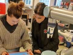 Josefine Larsson och Afsane Vosoughi programmerar en cobot från Universal Robots. Foto: SE Automation