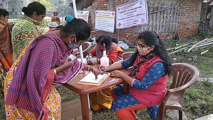Volontärer från Indiska Röda Korset rycker ut i den rekordhöga covid-smittan för att hjälpa människor med skyddsutrustning, information och även grundläggande förnödenheter. Foto: Indiska Röda Korset. 