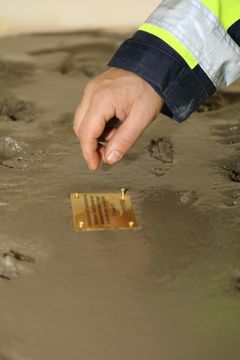 Namnplatta sätts på plats efter handavgjutningen. Foto: Trafikverket/NCC