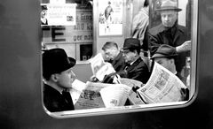 Tunnelbanepassagerare försjunkna i tidningsläsning, 1960-tal