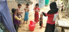 En volontär från bangladeshiska Röda Halvmånen visar barn i flyktinglägret Cox's Bazar hur man tvättar händerna.