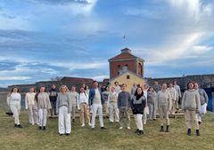 Rytmus Youth Choir repeterar vid Nya Älvsborgs fästning under ledning av Fredrik Berglund, i mitten i blått. Bildrättigheter: Rytmus, bilden får användas för redaktionellt bruk.