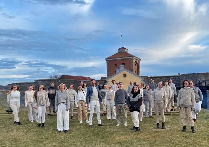 Rytmus Youth Choir repeterar vid Nya Älvsborgs fästning under ledning av Fredrik Berglund, i mitten i blått. Bildrättigheter: Rytmus, bilden får användas för redaktionellt bruk.