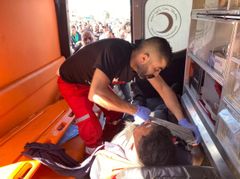 En sjukvårdare från Palestinska Röda Halvmånen tar hand om en skadad sjukvårdare från palestinska hemvärnet i staden Albireh.  