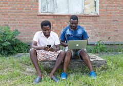 På Malawi har mobildata använts för att förstå var hälsokliniker gör mest nytta. Foto: Christopher Neu, TechChange/Dial
Syntolkning: Två män sitter utomhus med en bärbar dator i knät.
