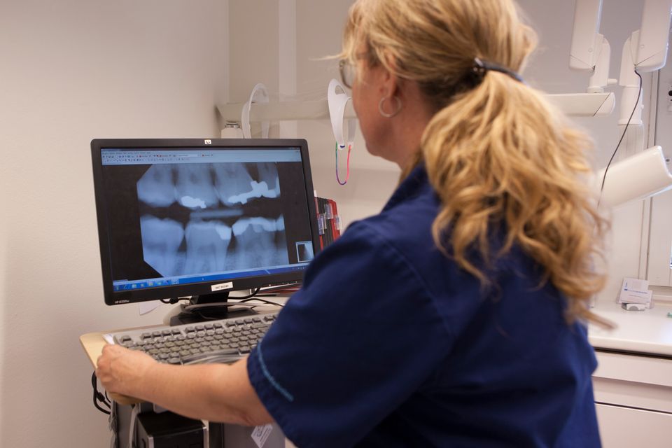 Tandläkare granskar en röntgenbild på en skärm