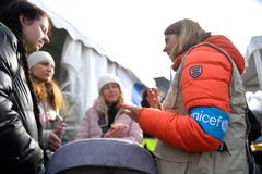 En familj på flykt får stöd och information vid den Blå punkt som Unicef har satts upp vid en gränsövergång mellan Ukraina och Rumänien. Foto: Unicef/Nicodim