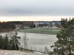 Området där den nya fotbollshallen ska placeras. Bortom fotbollsplanen skymtar Väsby centrum. Cirka 100 meter söder om grusplanen (till vänster i bilden) ligger friidrottsplatsen.