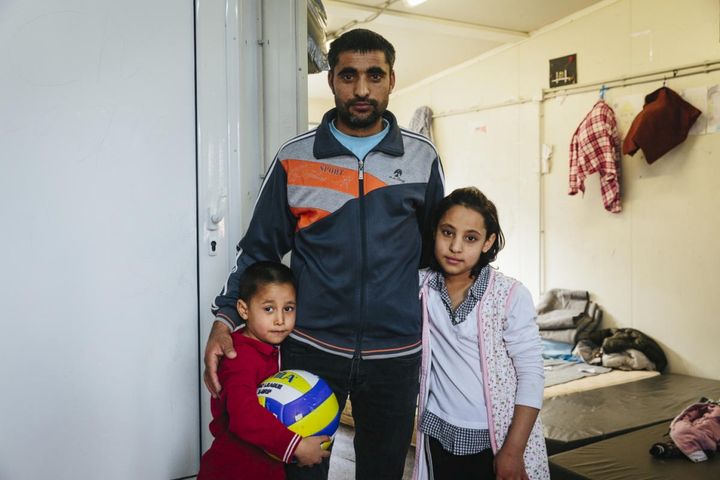 En afghansk asylsökande står med två av sina barn i ett mottagningscenter i Fylakio, Grekland, i februari 2020. © UNHCR / Achilleas Zavallis