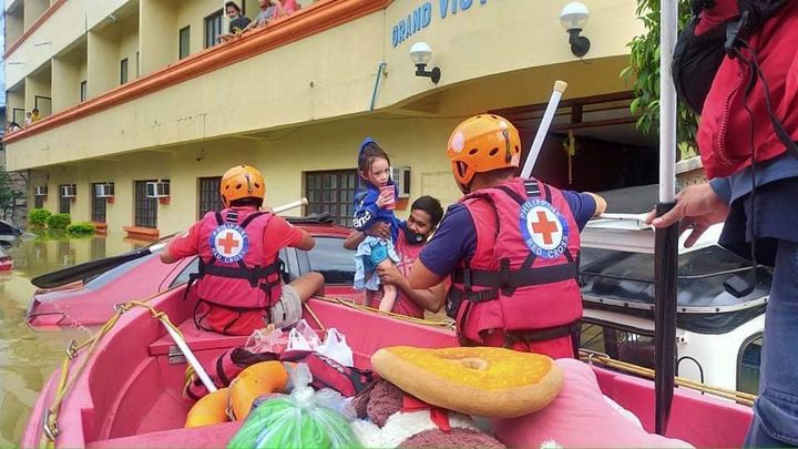Räddningsarbetare från filippinska Röda Korset hjälper människor drabbade av översvämningar efter tyfonen Vamco.