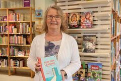 Katarina Ströberg håller i en bok med titeln rum för läsning.