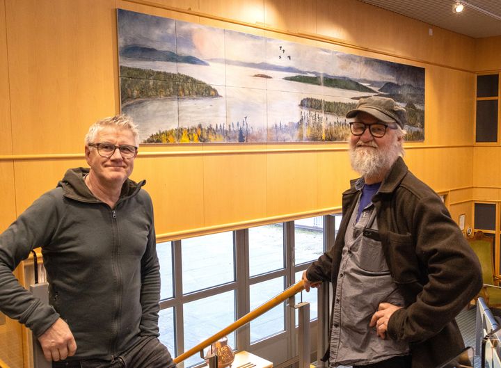 Leif Wikberg och Mikael Arvidsson framför konstverket som är en emaljbild med vy från Höga Kusten