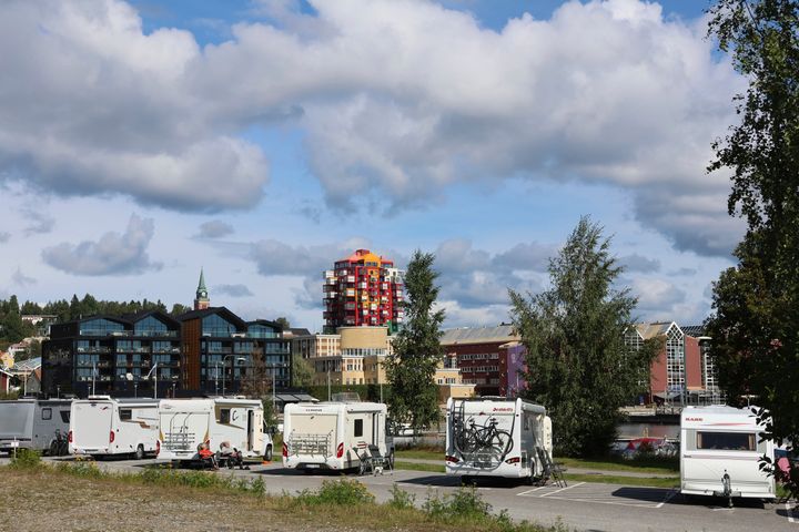 Husbilar och husvagnar uppställda på Varvskajen med  utblick över stadskärnan där det färgglada huset Ting1 sticker upp