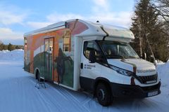 Biblioteksbussen parkerad på en snöoíg "hållplats"  ute på landsbygden.
