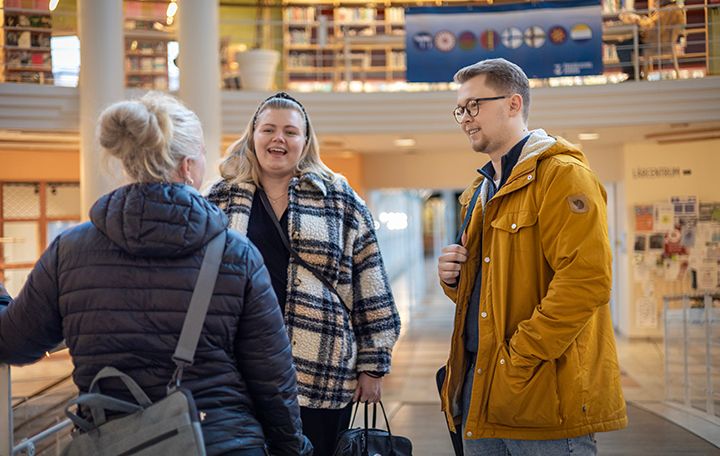 tre studenter på gångbro utanför Campus lokaler i Arken