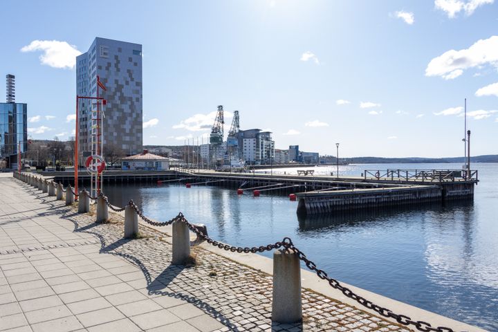 Bild av ett kajområde i centrala Örnsköldsvik med moderna byggnader och en brygga vid vattnet.