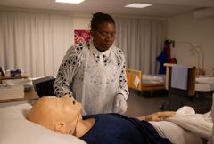 Nyasha Mayau står vid en säg där en patientdocka ligger.