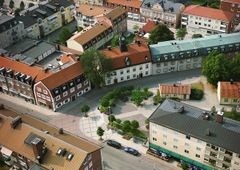 Flygbild över ett öppnat torgområde i Enköping med omgivande byggnader, planteringar och promenadstråk.
