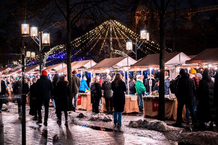 Människor går runt bland marknadsstånd på julmarknaden i Kungsträdgården