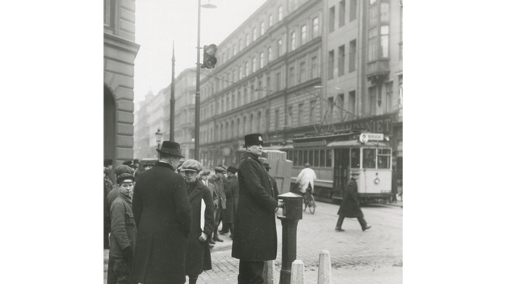 En polis styr det manuella trafikljuset, för 100 år sedan, i korsningen mellan Vasagatan och Kungsgatan i Stockholm.