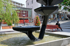 En fontän i förgrunden och ett torg i bakgrunden.