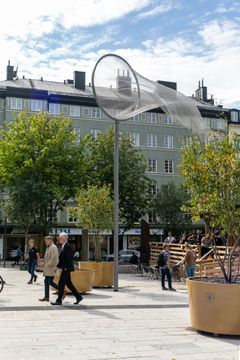 Konstverk på torg. Liknar en håv.