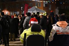 Personer med tomteluva i förgrunden, folksamling i bakgrunden.