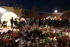 Blommor i förgrunden, människor och julbelysning i bakgrunden på Sätra torg.