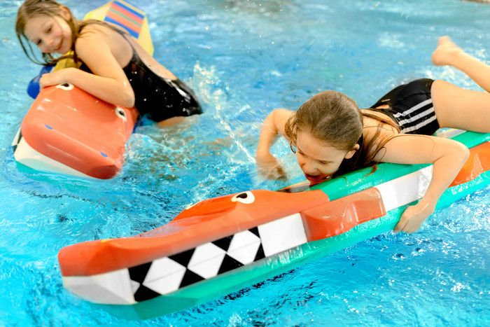 Två barn med leksaker i en bassäng